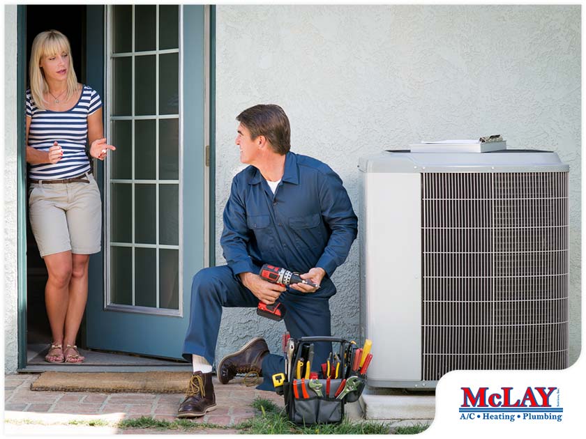 ac repair technician discussing repairs with homeowner