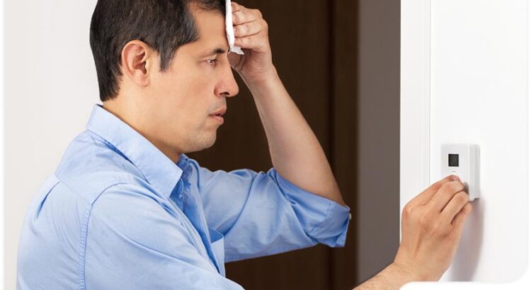 man wiping sweat from brow